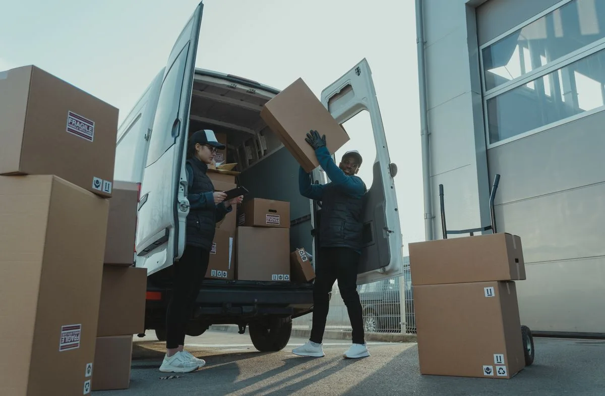 Workers loading boxes into a cargo vehicle